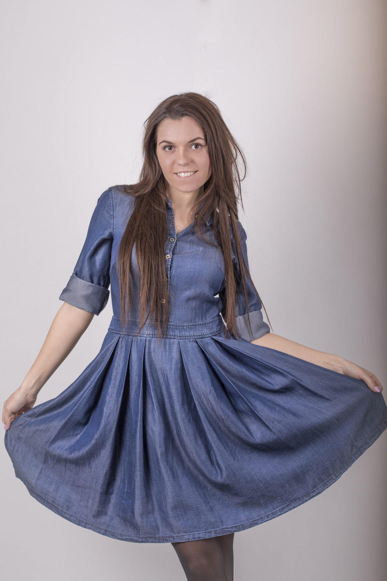 Portrait in blue dress mid-twirl