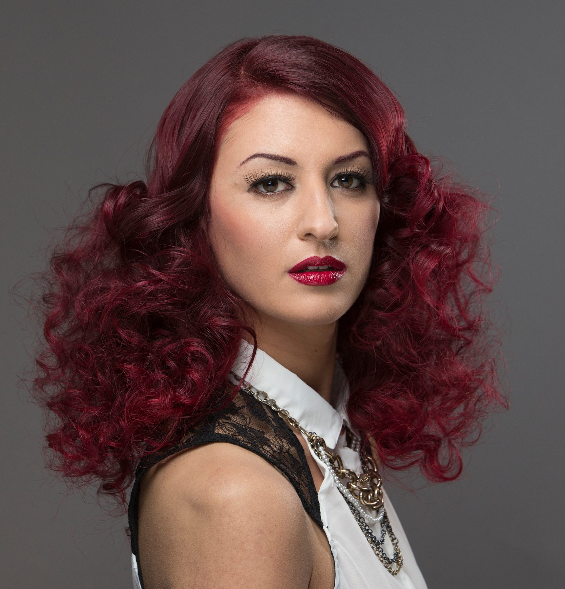 Portrait with sculpted deep-red curls and lace top